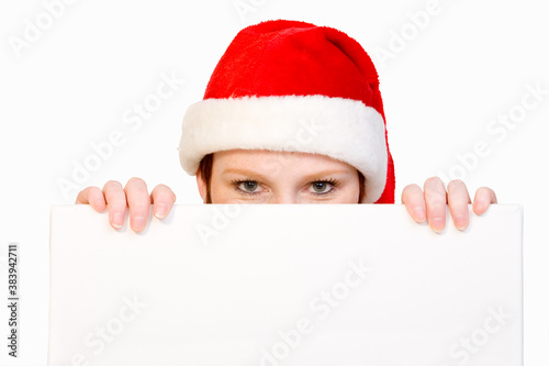 Christmas girl holding up a white sign for copyspace photo