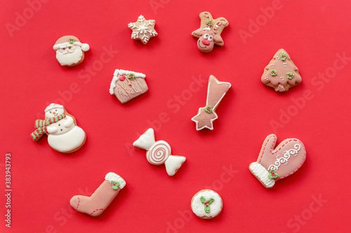 Decorated Christmas gingerbread on red background, top view