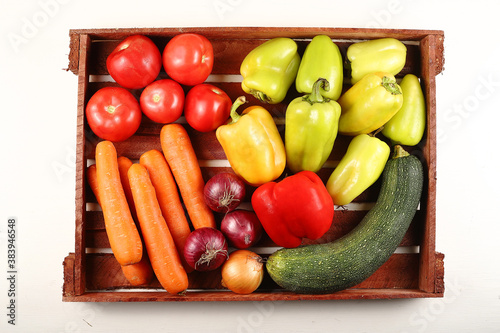 Juicy ripe vegetables on a wooden tray onions. Flat lay.