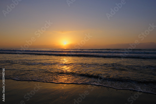 a glorious orange sunrise over a calm blue sea