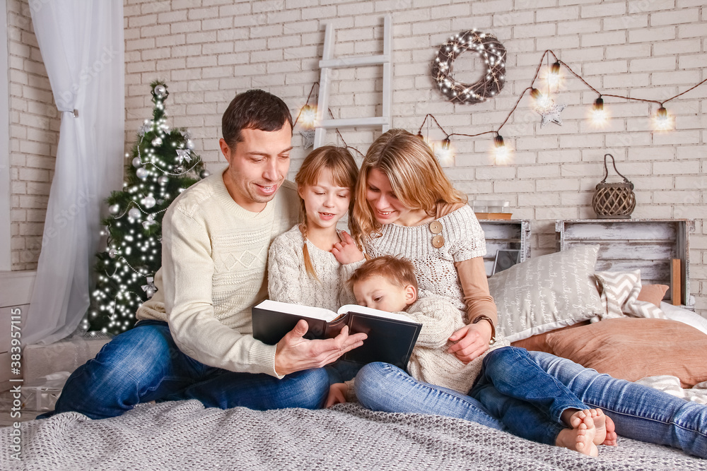 happy family reading a book at home at christmas happy family reading a book at home at christmas