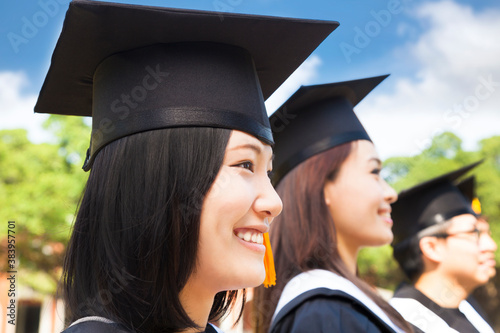 фотографія smiling female college graduate standing with classmate