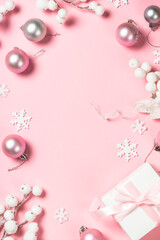 Christmas present box and decorations on pink background.