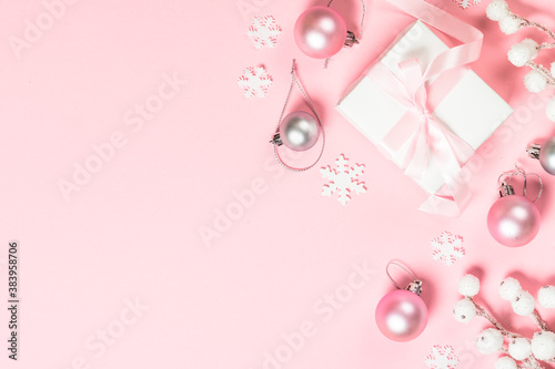 Christmas present box and decorations on pink background.