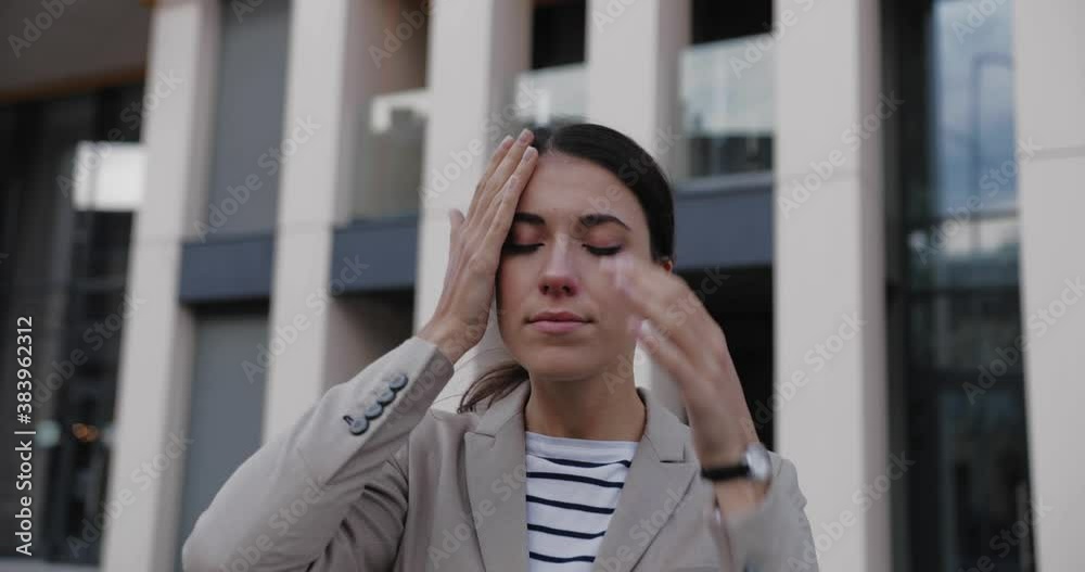 Close up portrait of Caucasian unwell young female having headache and touching her throat with her fingers while standing outdoor in city. Beautiful sick female not feeling well in city Virus concept Close up portrait of Caucasian unwell young female having headache and touching her throat with her fingers while standing outdoor in city. Beautiful sick female not feeling well in city Virus concept