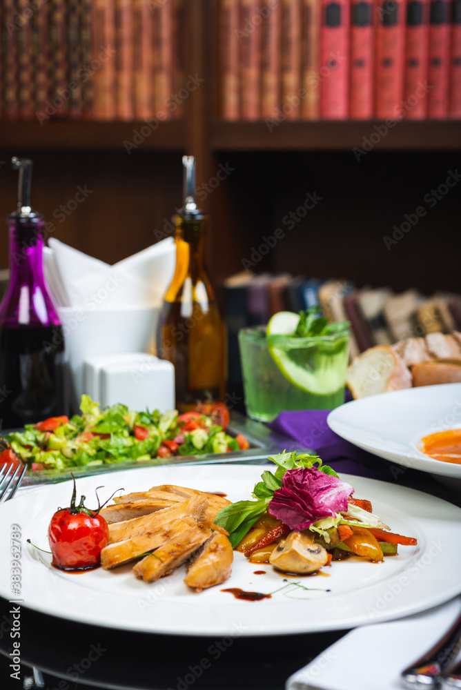 Baked chicken breast with vegetables and sun-dried tomatoes on a plate