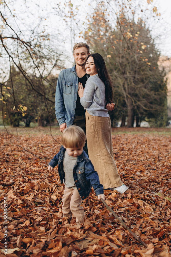 Fototapeta premium happy family mother father and baby on autumn walk in the park