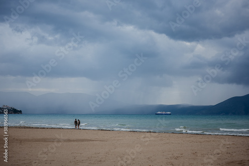 Couple walking on the beach on the rainy day