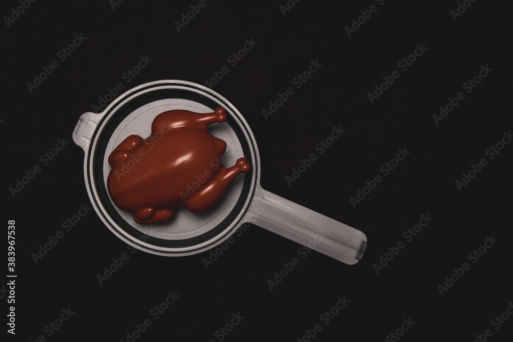 Chicken on a frying pan on a dark background. Children's kitchen. Plastic toy Chicken on a frying pan on a dark background. Children's kitchen. Plastic toy