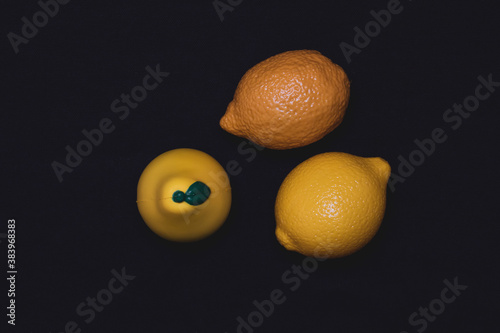 Photos of toy fruits on a dark background. Plastic toy