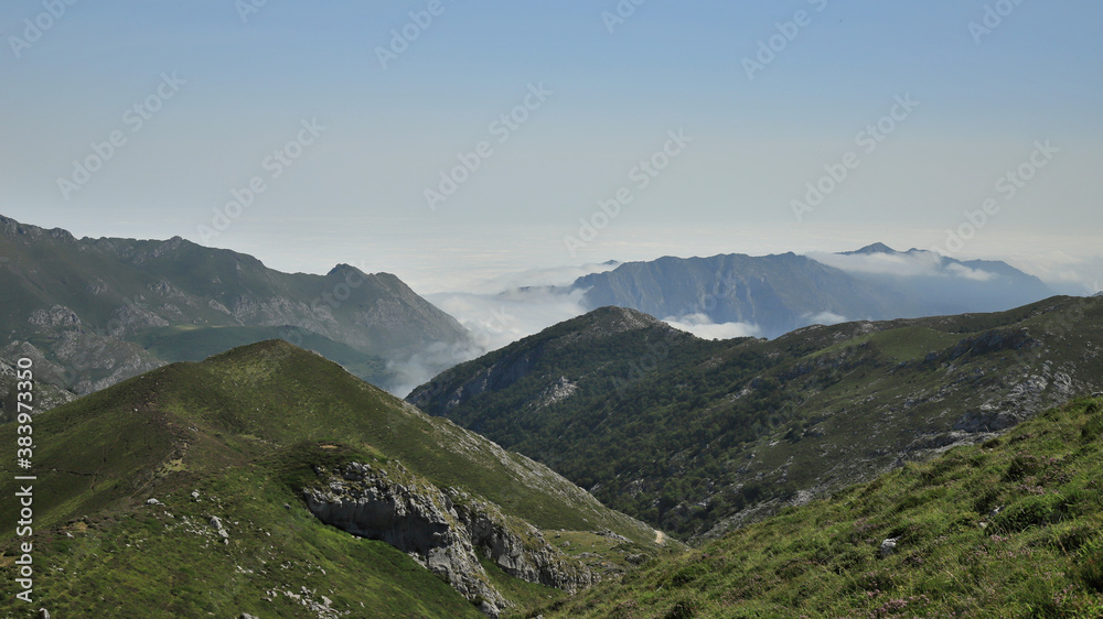 landscape with mountains, fog and blue sky