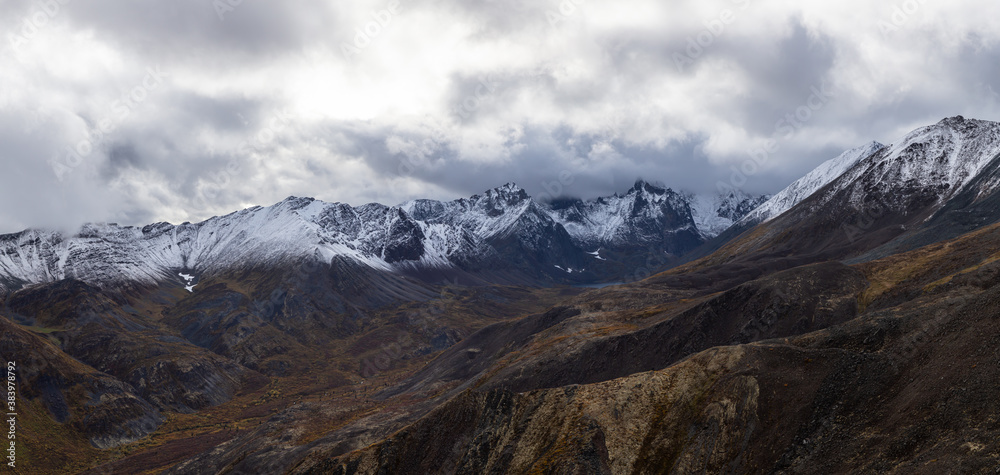 Beautiful Panoramic View of Scenic Landscape and Snowy Mountains in Canadian Nature. Season change from Fall to Winter. Aerial Shot. Near Grizzly Lake in Tombstone Territorial Park, Yukon, Canada.