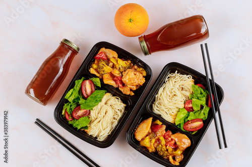 Ready meal to eat on food container with drink and chopstick.