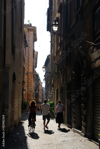 A couple and a bicyclist navigating narrow backstreet of Rome © Reimar