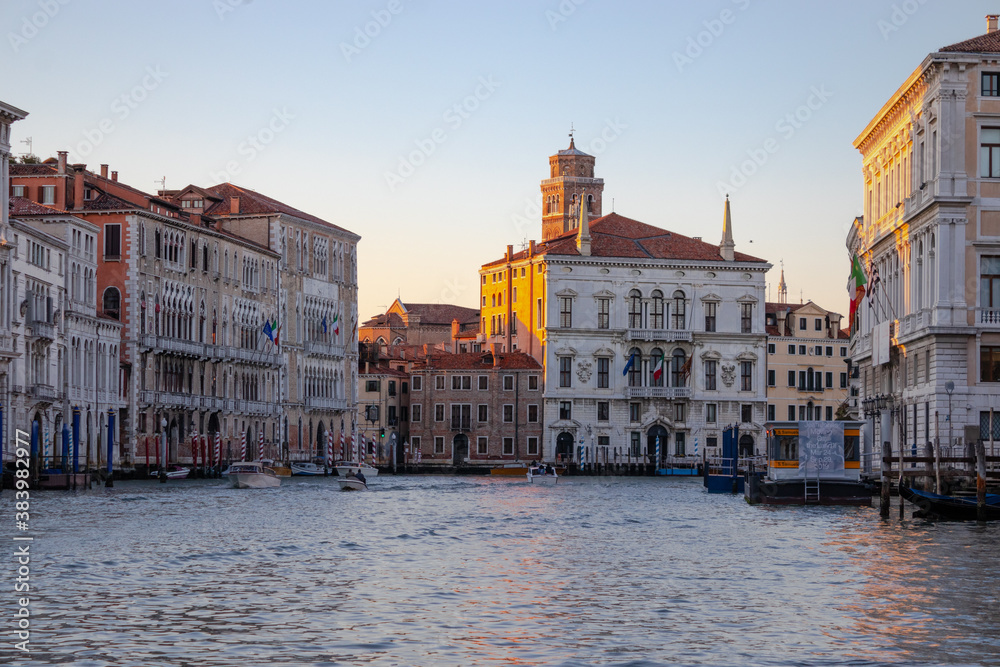 Fototapeta premium The setting sun glowing against buildings lining the Grand Canal