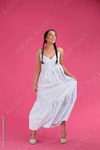 Tableau sur toile Young woman wearing stylish dress on pink background