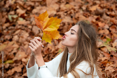 Autumn beauty. Woman fashion wodel with fall maple leaf outdoors.