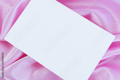 Fotografie White card on pink satin