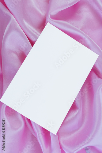 Fotografie White card on pink satin