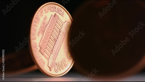 Super slow motion shot of pennies spinning around against a dark background photo