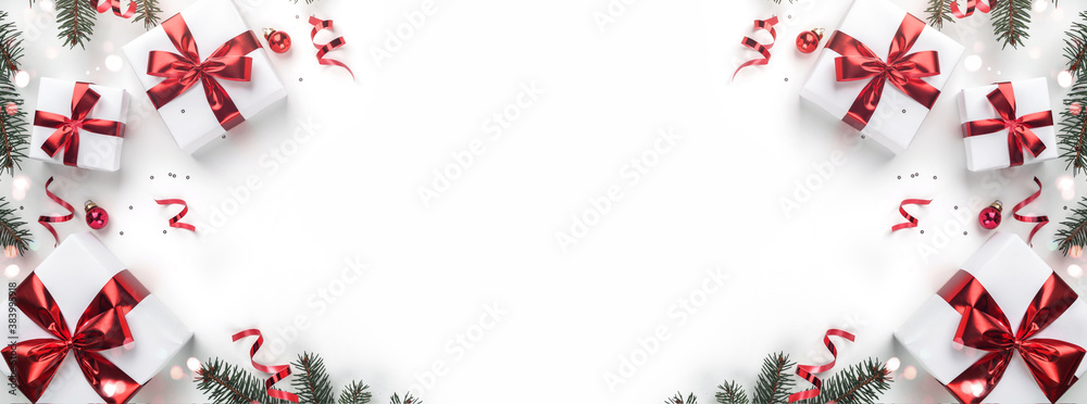 Creative frame made of Christmas fir branches, gift boxes, red decoration, sparkles and confetti on white background. Xmas and New Year holiday, bokeh, light. Flat lay, top view Creative frame made of Christmas fir branches, gift boxes, red decoration, sparkles and confetti on white background. Xmas and New Year holiday, bokeh, light. Flat lay, top view
