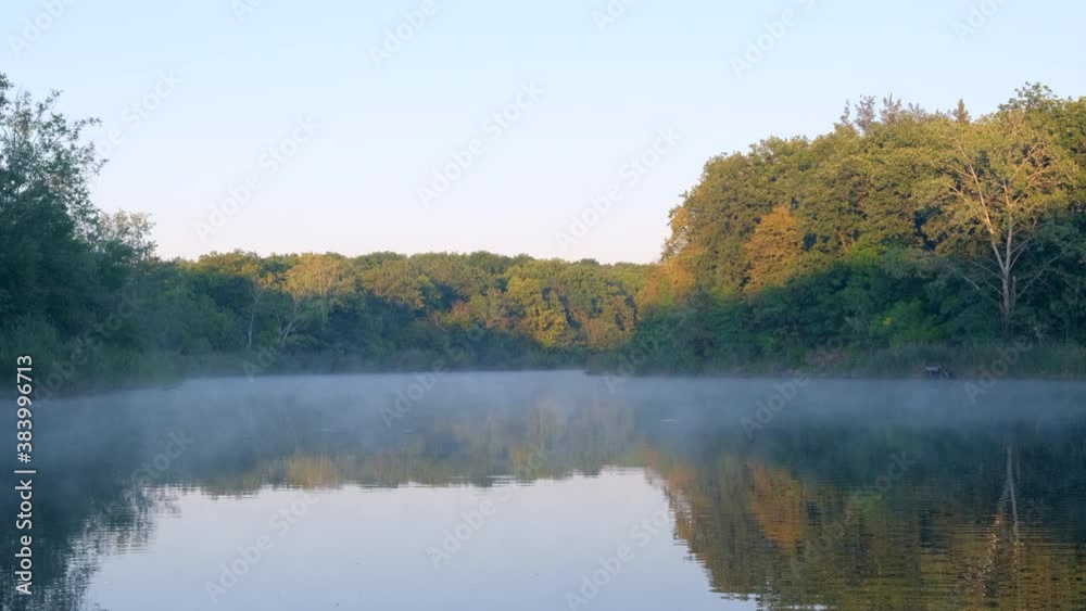 Foggy river. Calm morning on the river in the fog, trees reflected in the water. Silence and natural beauty. Nature in autumn Foggy river. Calm morning on the river in the fog, trees reflected in the water. Silence and natural beauty. Nature in autumn