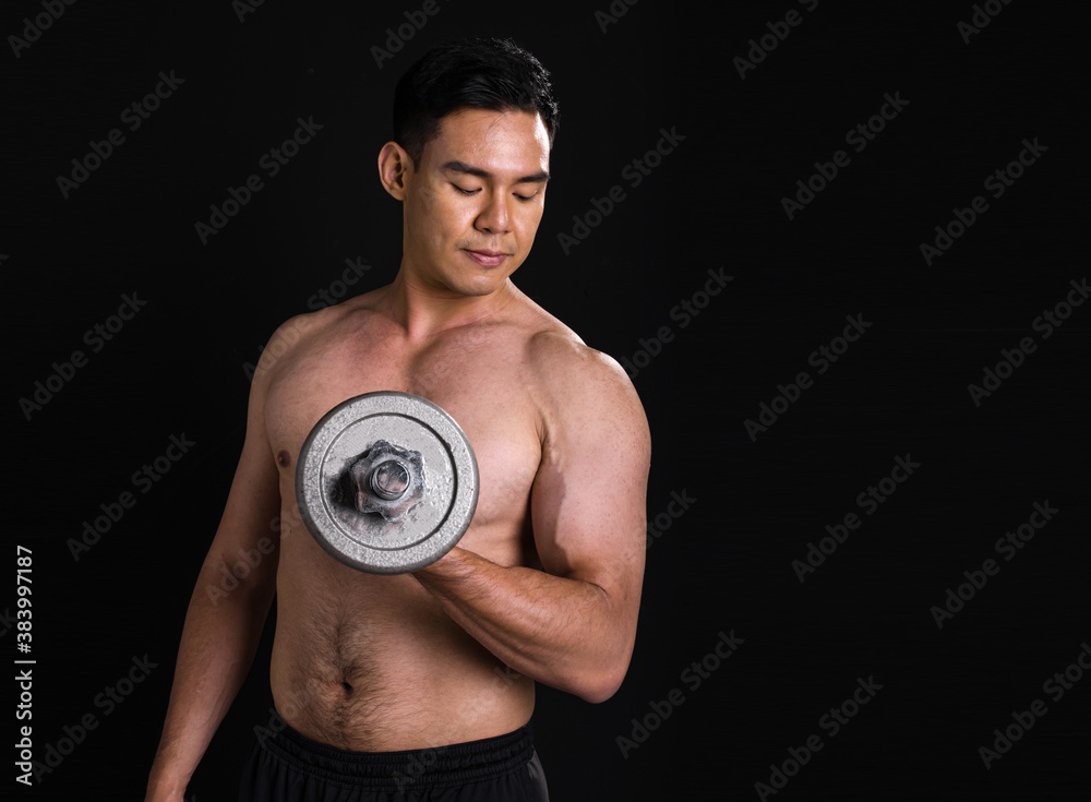 Portrait of asian muscular man standing and lifting dumbbell on black background Portrait of asian muscular man standing and lifting dumbbell on black background