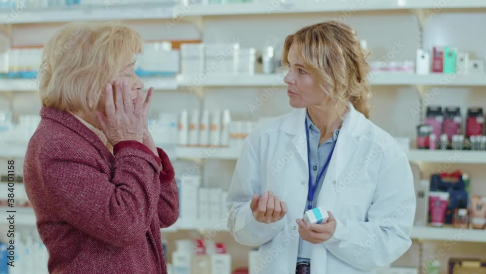 In a drugstore woman pharmacist serving a customer. Conversation pharmaceutical client. Seller commercial health care buyer uniform. Slow motion In a drugstore woman pharmacist serving a customer. Conversation pharmaceutical client. Seller commercial health care buyer uniform. Slow motion