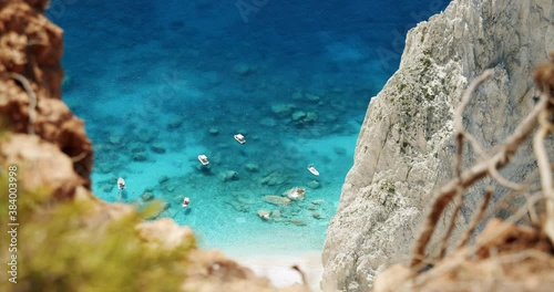 Tourest pleasure boats in blue sea lagoon framed by nature arid dry ground, Greece photo