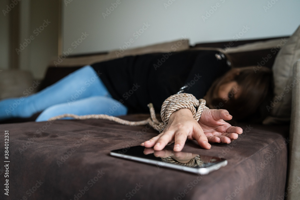 Close up on tied hands of unknown caucasian woman lying on bed at hotel  room desperate