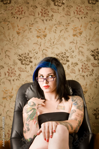 Pretty Woman with Tattoos in a Leather Chair