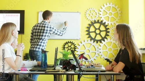 Group of students working together in classroom with laptops