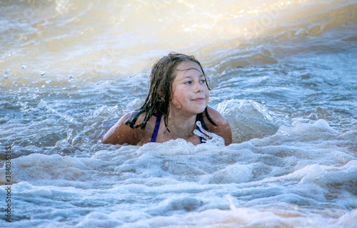 Beautiful young girl  swimming in the surf on the shores of Lake Michigan 