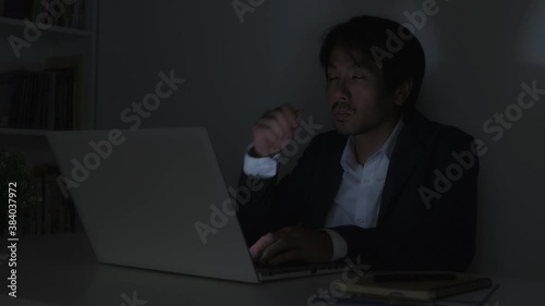 Asian Insurance Agent Businessman in Suit Rubbing Eyes and Working Late at Office