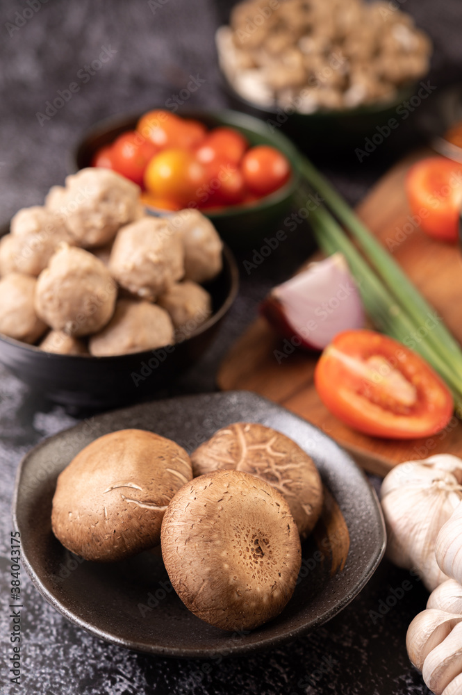 Shiitake mushrooms with garlic, tomato, capsicum, spring onion and red onions on a black cement floor. Shiitake mushrooms with garlic, tomato, capsicum, spring onion and red onions on a black cement floor.