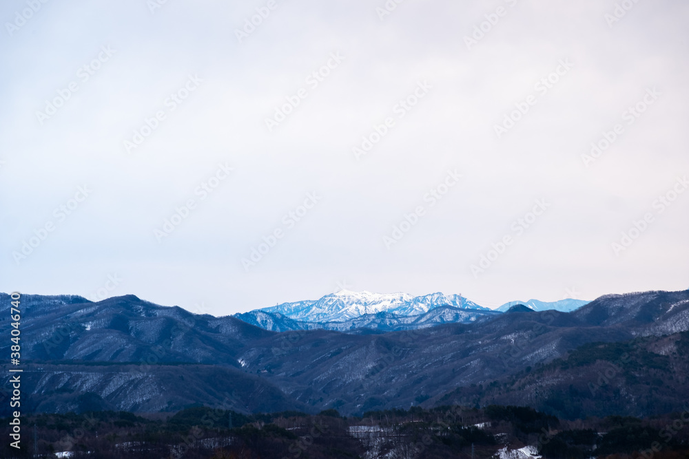 Landscape of big mountain range with snow on top in winter view from Kusatsu Onsen,  Japan