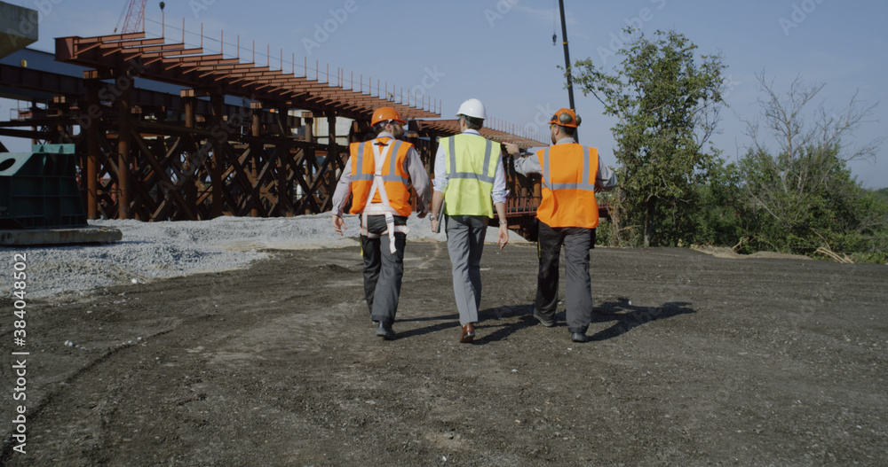 Fototapeta premium Professional engineers walking towards unfinished bridge