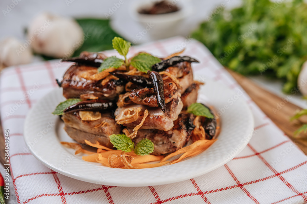 Fried Pork with Fried Chili Fried onion and mint in a white plate. Fried Pork with Fried Chili Fried onion and mint in a white plate.