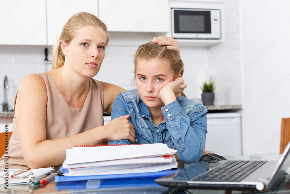 Fototapeta premium Mother calming her daughter who upset by her studies at kitchen table