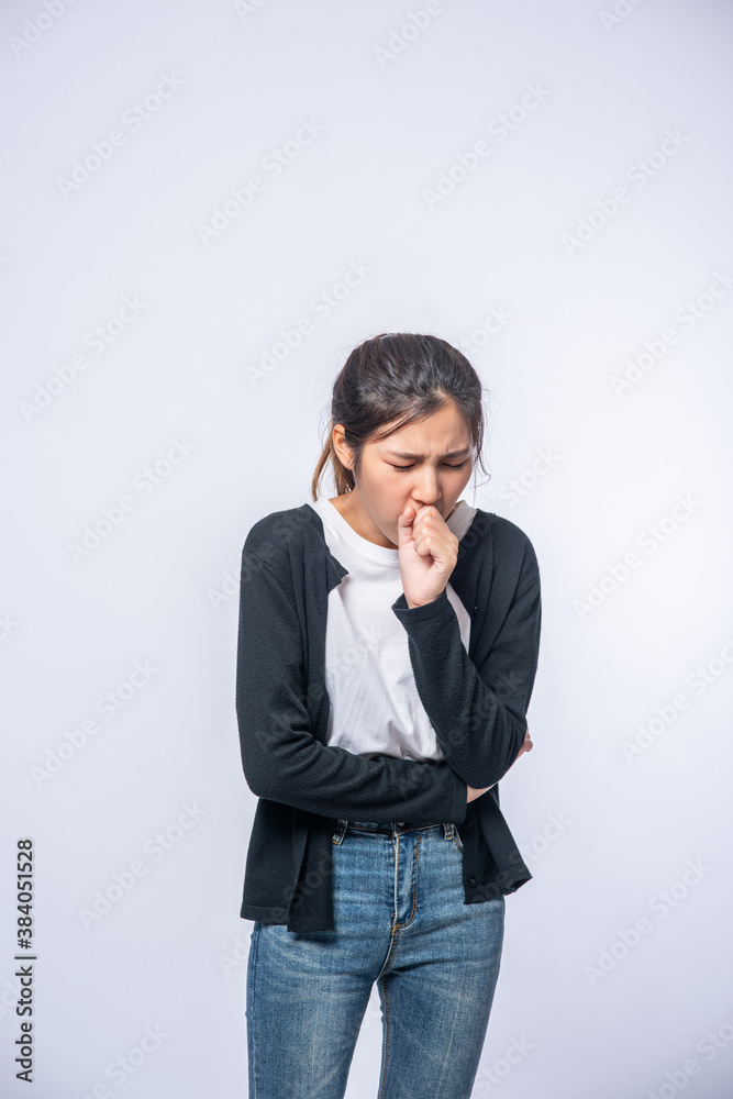 A woman coughing and covering her mouth with her hand A woman coughing and covering her mouth with her hand