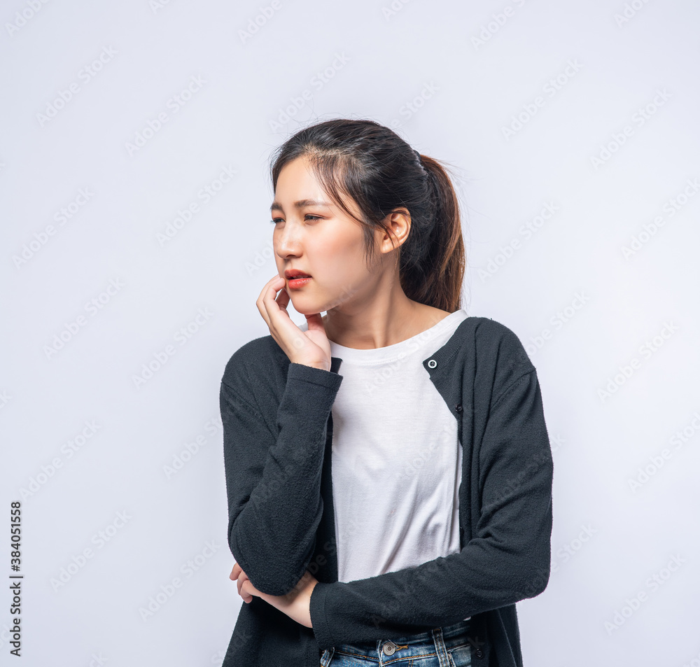 A woman sick with a toothache and a hand holding on the cheek