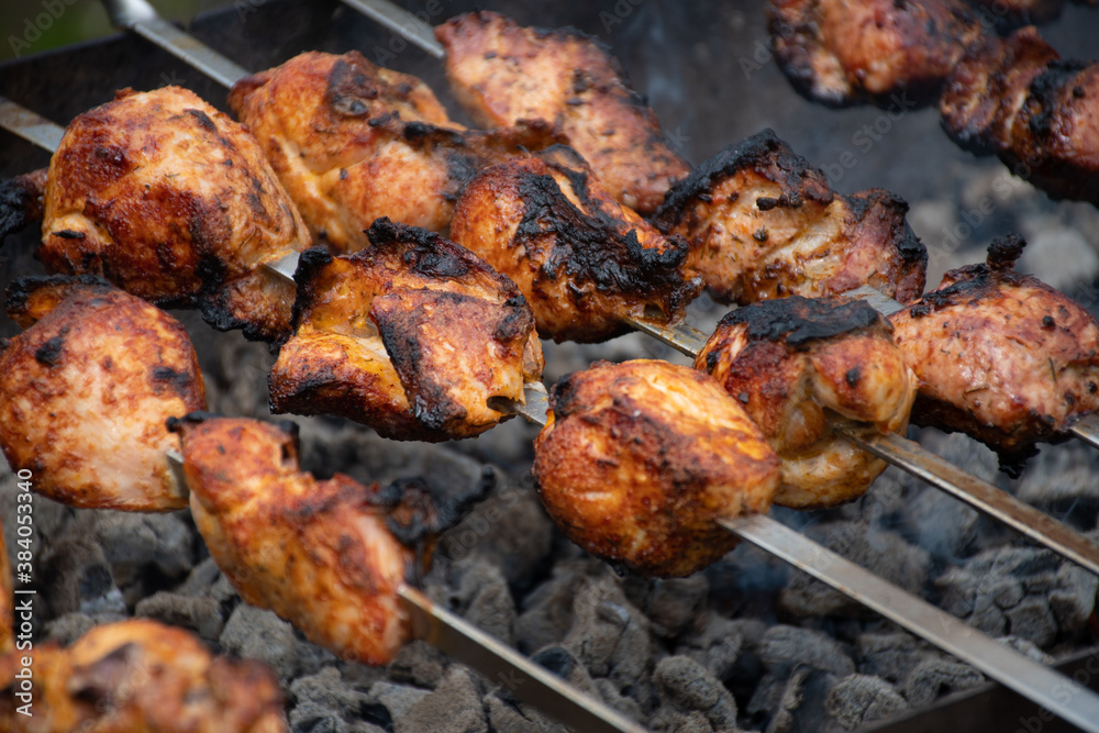 Cooking meat and delicious food concept. Meat on skewers. Marinated shashlik preparing on a barbecue grill over charcoal. Appetizing meat grilled on skewers. Cooking shashlik. Grilling pork on coal