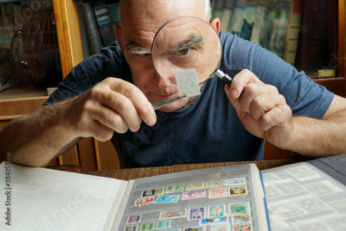  An elderly man examines a brand through a magnifying glass. photo