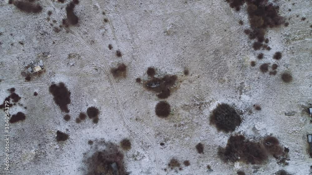 Flight over the winter flat landscape. A rare forest between large meadows. Winter, some snow