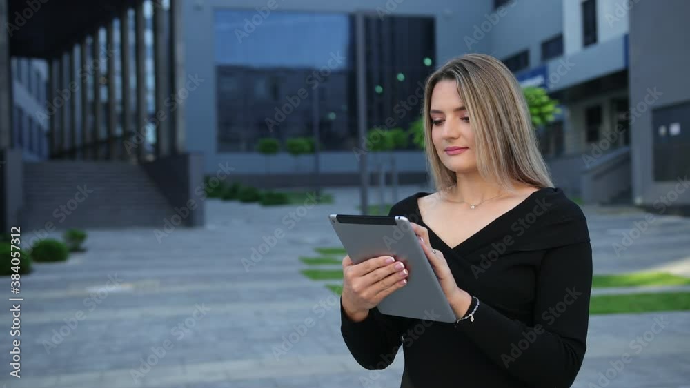 Beautiful young woman using tablet pc in the city. Closeup on business lady with digital pad. Businesswoman electronic computing device standing outside an office megapolis. Beautiful young woman using tablet pc in the city. Closeup on business lady with digital pad. Businesswoman electronic computing device standing outside an office megapolis.