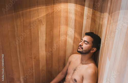 Young handsome man in sauna at spa center