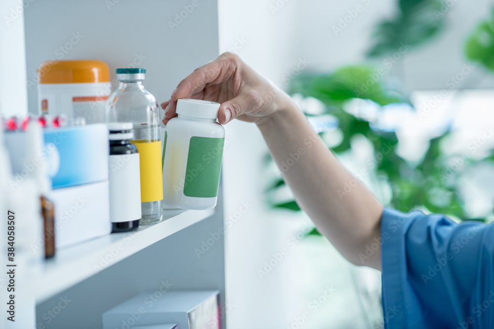 Close up of doctors hands taking a bottle with vitamins