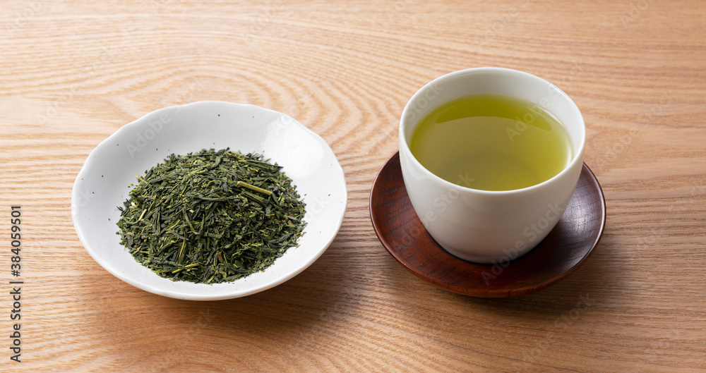 Green tea and tea leaves on a wooden tray Green tea and tea leaves on a wooden tray