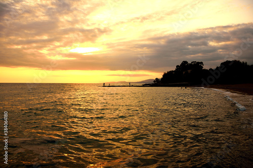 Fishermens on the sea pier during the summer sunset.