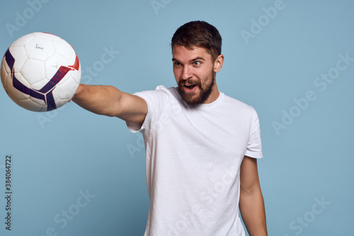 male coach with soccer ball on blue background cropped view Copy Space